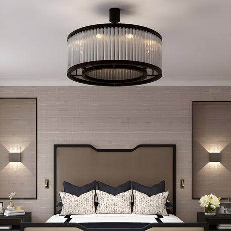 A modern bedroom with a large, round ceiling light fixture, a neatly made bed with decorative pillows, and beige textured walls adorned with two framed wall lights.