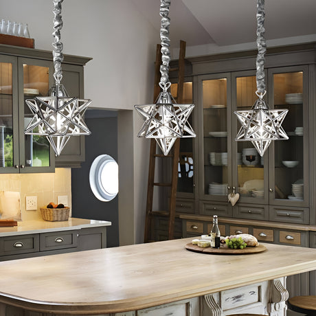A kitchen with three star-shaped pendant lights above a wooden island. There are cabinets with glass doors, a circular window, a basket of fruit, and a bottle with seasoning on the counter.