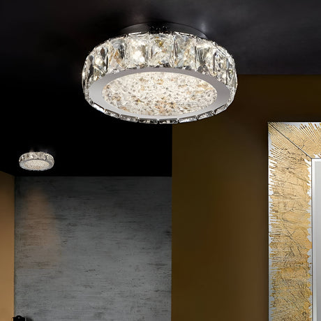A modern ceiling light fixture with a circular design, featuring crystal accents, illuminates a room with dark walls and gold accents. Another smaller matching fixture is visible in the background.