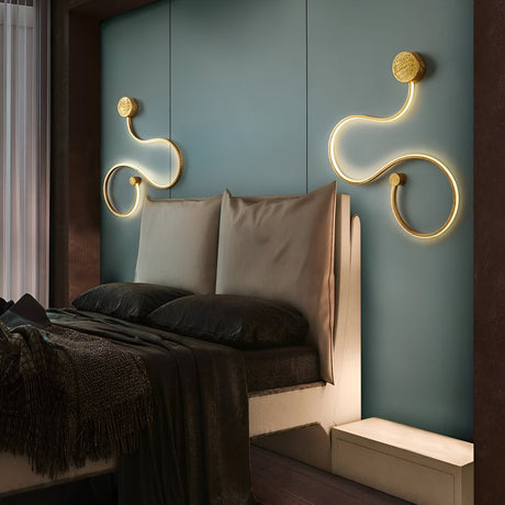 A modern bedroom with a teal accent wall features a double bed with beige pillows and blankets. Artistic looped wall lights create a contemporary look above the bed. A curtain covers the window to the left.