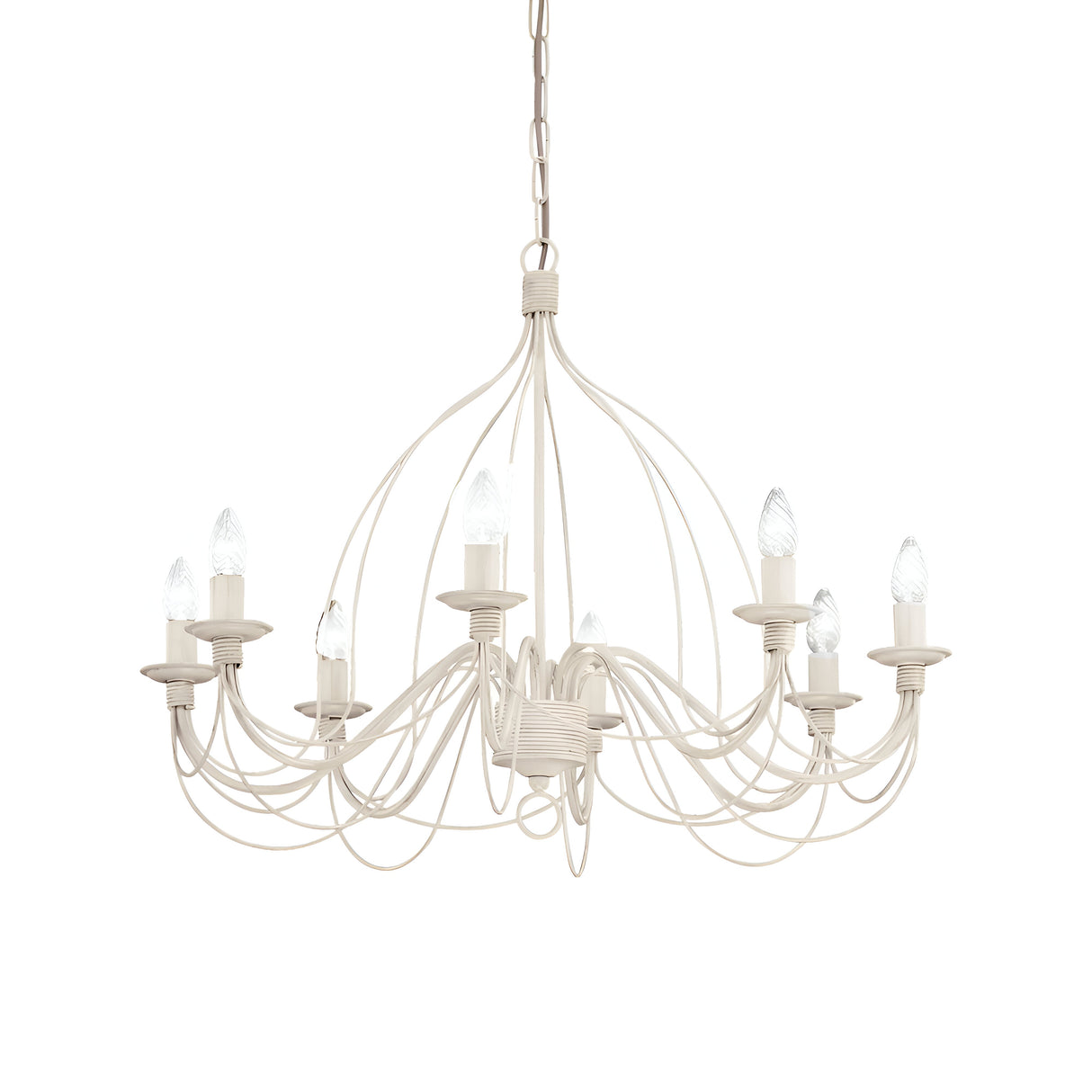The Seraph 8 Light Chandelier - White embodies elegance with its gracefully curved metal arms and eight candle-shaped bulbs, all highlighting exquisite traditional craftsmanship. Suspended from a chain, it evokes an antique ambiance against the white backdrop.