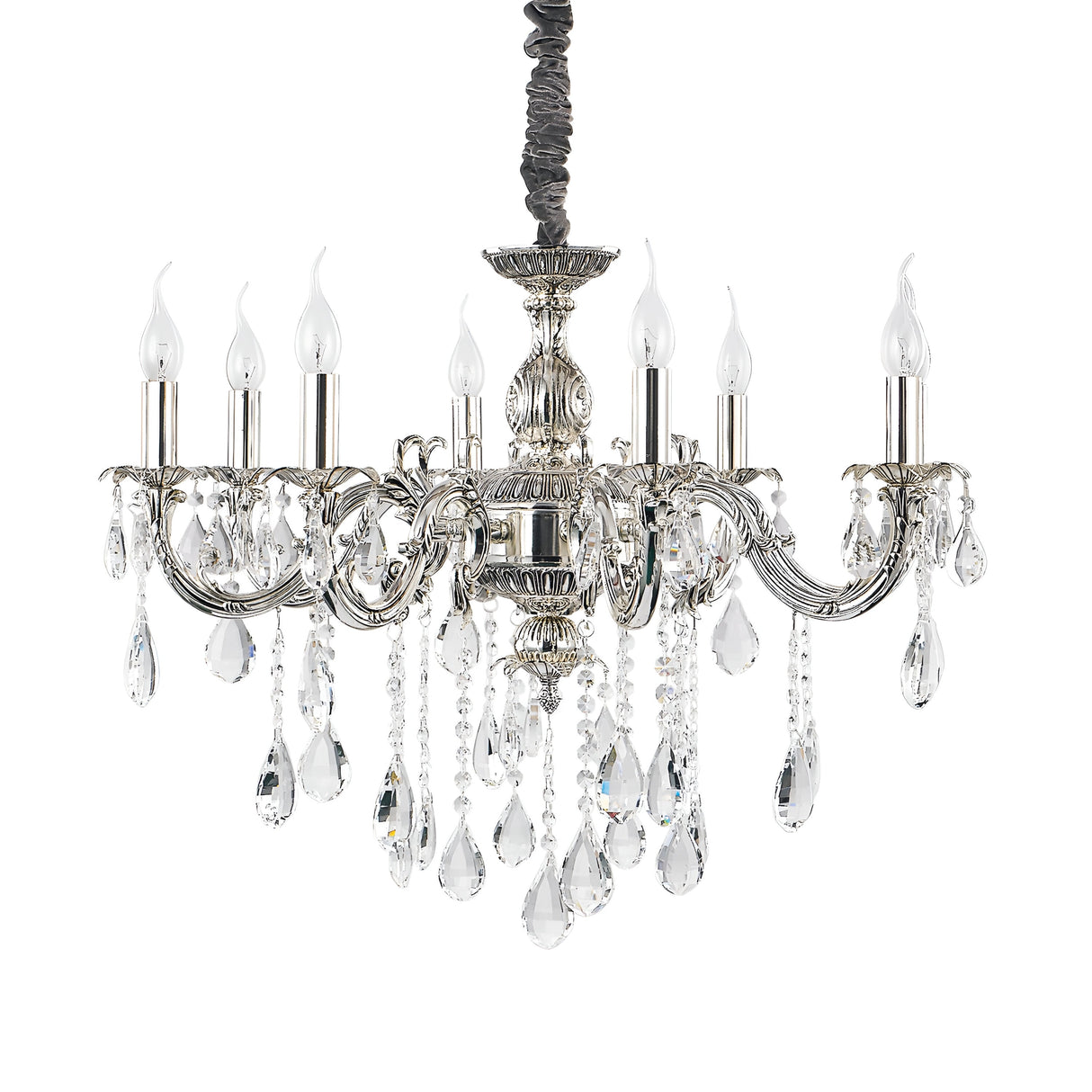 The Aetherial 8 Crystal Light Chandelier - Grey boasts an antique silver finish and features eight candle-shaped lights on intricately designed arms. Clear crystal pendants dangle from the chandelier, elevating its luxurious appeal, while a decorative metal center column adds a vintage charm. This piece is perfect for upscale interiors.