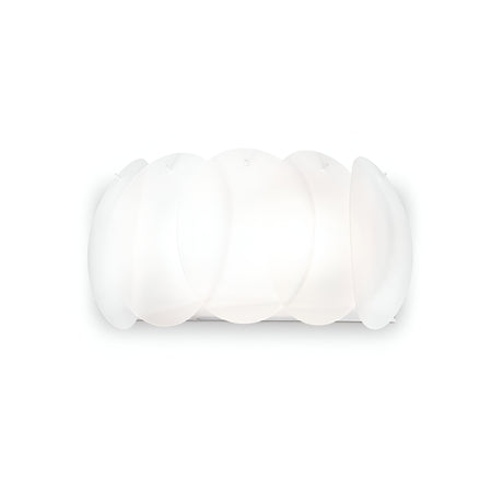 Introducing the Nero 2 Light Wall Light - White: a contemporary wall sconce designed with four overlapping, translucent oval panels made from acid-etched glass. It casts a gentle glow against a simple background and embodies an elegant minimalist aesthetic.