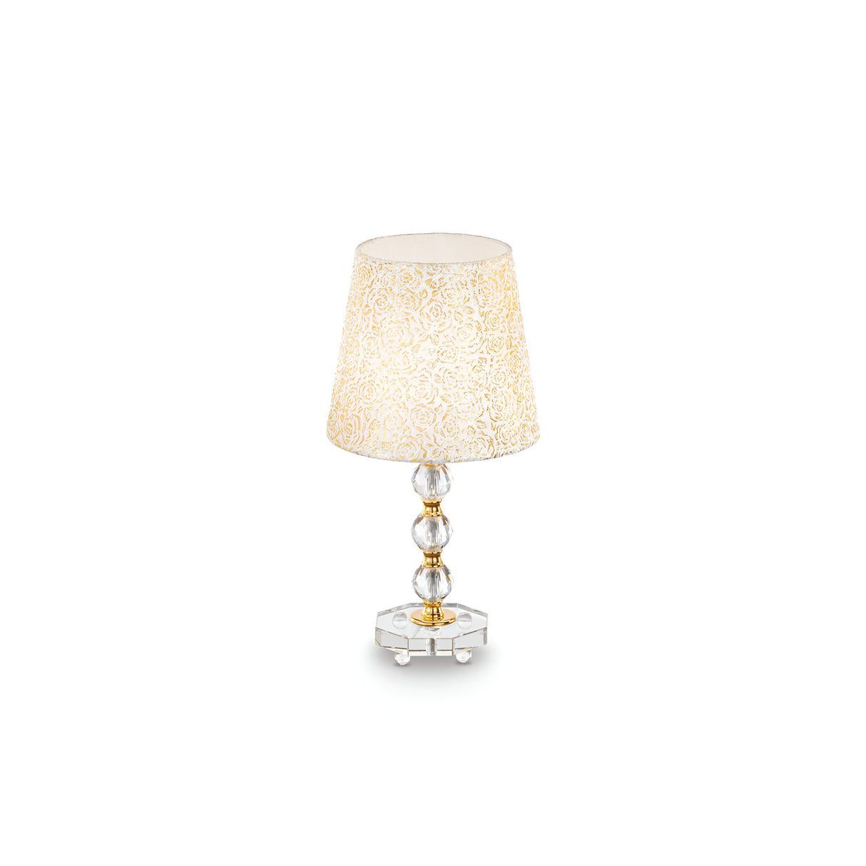 The Princess Medium Crystal Table Lamp - Gold, with an elegant glass base featuring round, stacked crystals and a beige intricately patterned shade, gleams against a plain white background.