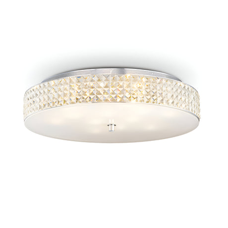 The Nebula 12 Light Crystal Ceiling Light in chrome showcases a sleek, round design with a frosted glass base, complemented by an elegant crystal-like band around the side. Its modern style adds sophistication while providing a soft and ambient glow.