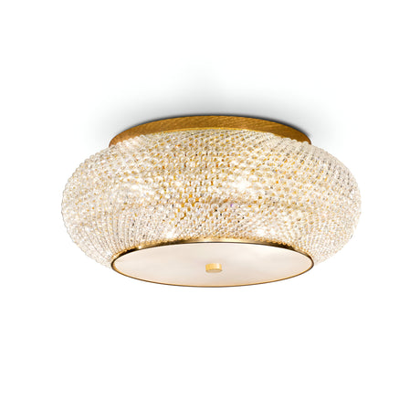 The Harbor 10 Light Crystal Flush - Gold features a modern circular design, complete with a golden base and a textured crystal-like surface that emits a warm glow. This gold ceiling light boasts a smooth, round bottom plate accentuated by a small central knob for an elegant touch.