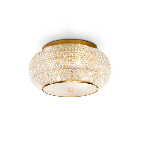 This Harbor 6 Light Crystal Flush - Gold showcases an elegant ceiling-mounted, circular design with a textured gold surface. It features intricate crystal-like details that cast beautiful reflections, and the base plate is adorned with a smooth matte gold finish and a central knob for added sophistication.