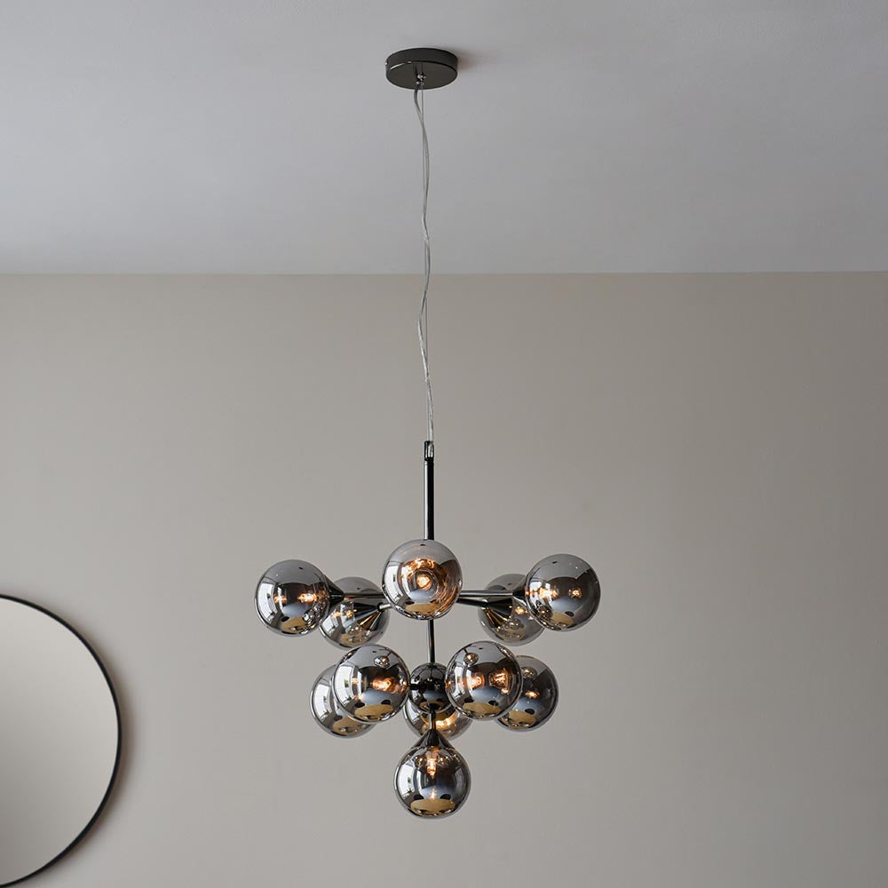 Endon Fitzroy 11 light pendant in black chrome with tiered smoked mirror glass globes, suspended from a ceiling near a round mirror.