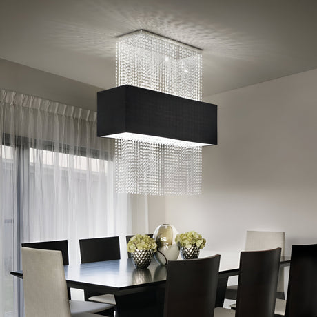 In a sleek dining room, the Lustrous Crystal 5 Light Ceiling Chandelier in Chrome/Black elegantly illuminates a dark wooden table, exuding modern luxury. High-back chairs encircle the arrangement, complemented by a glass vase centerpiece and sheer floor-length curtains that frame an expansive window, showcasing contemporary design at its finest.