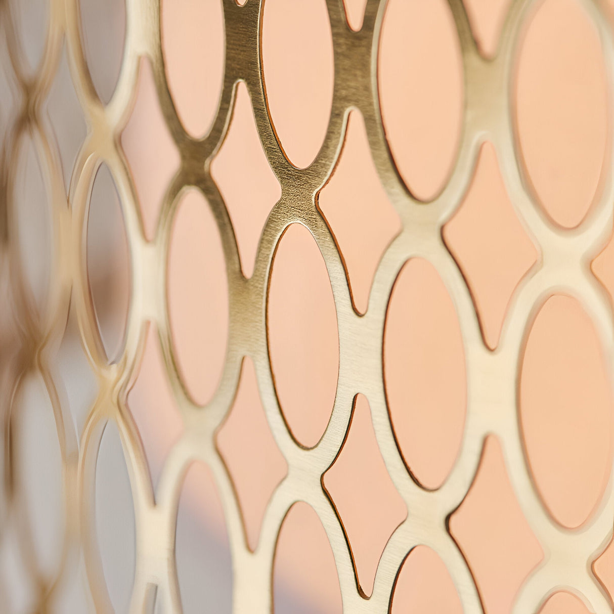 Close-up of the Rosaline 3 Light Pendant's gold metal outer shade, showing a circular geometric fretwork pattern over a pale inner surface.