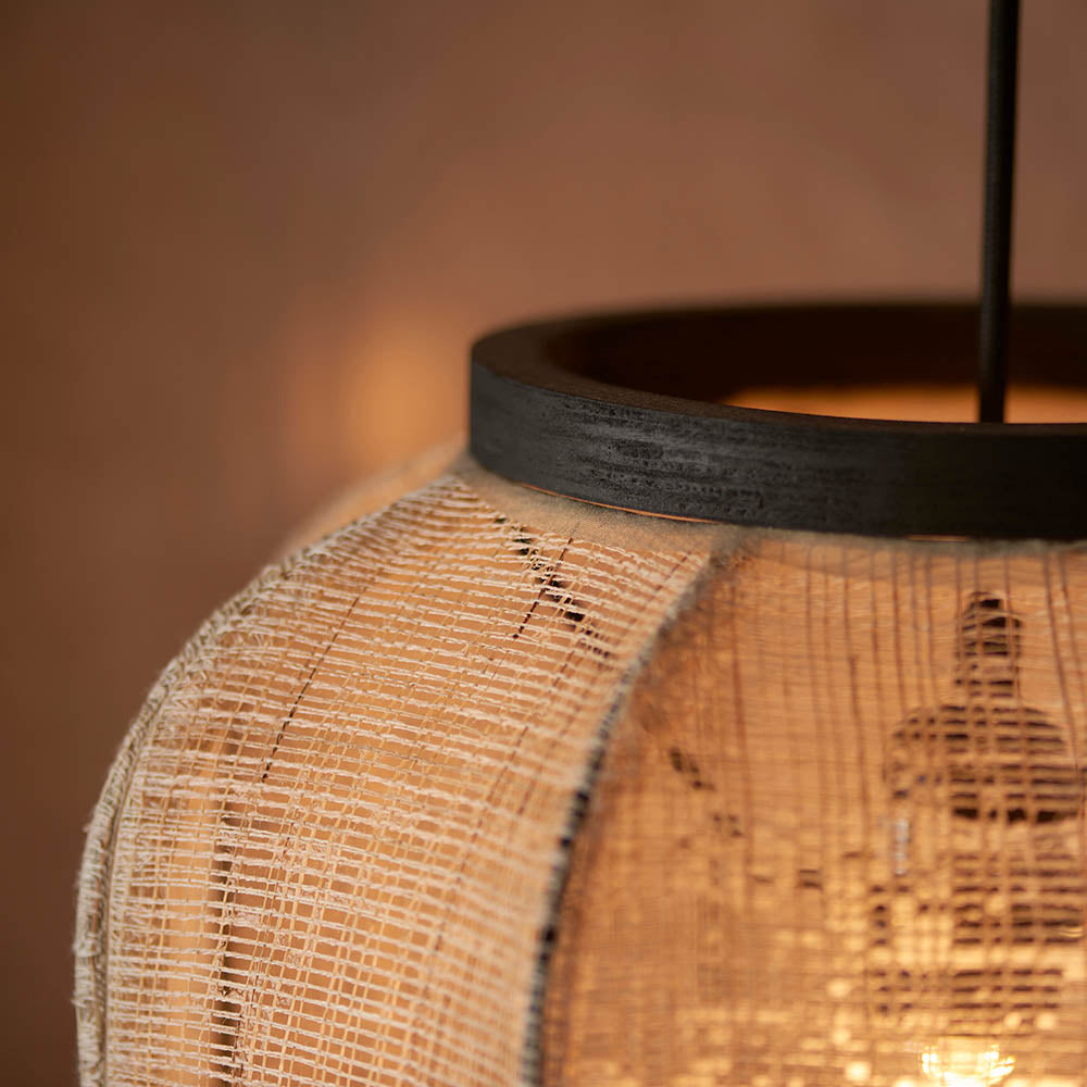 Close-up of the Endon Daneshaw pendant showing its handmade natural linen shade, matt black wooden rim, and glowing E27 filament bulb within.