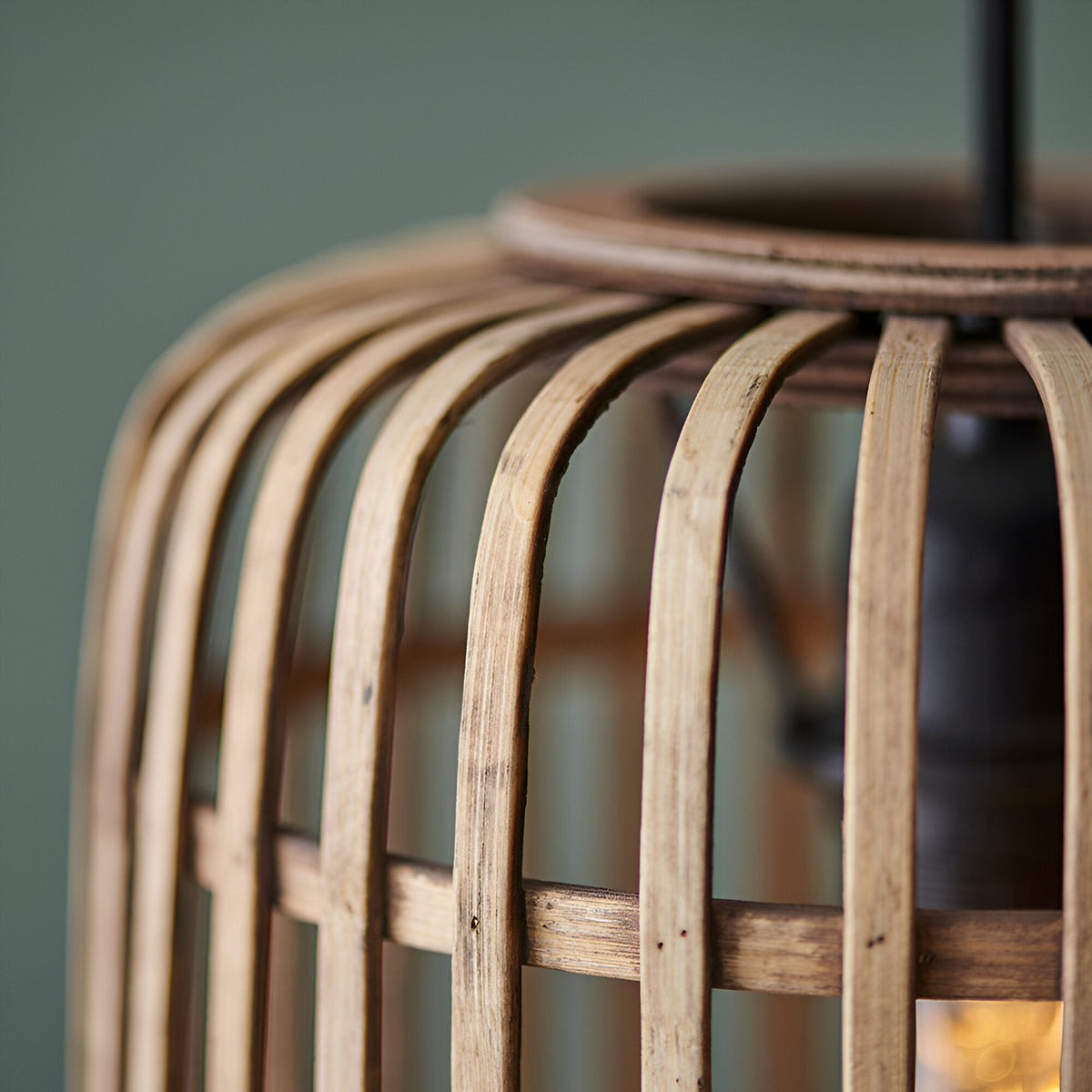 Close-up of the Endon Bracken pendant light showing the open natural bamboo cage and matt black metal top ring against a soft green backdrop.
