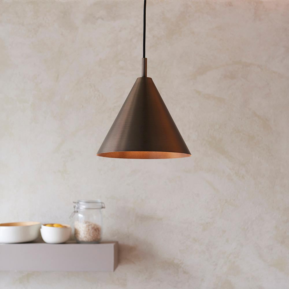 Endon Ashworth cone pendant light in brushed antique bronze with matching painted inner and black cable, hung above a shelf with bowls and a jar.