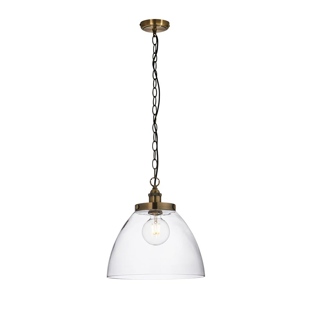 Wentworth Pendant in brass with a domed clear glass shade, exposed filament bulb, and adjustable chain suspension, shown on a plain white background.