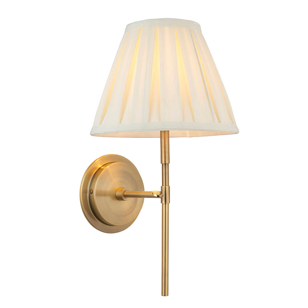 Endon Chartwell wall light with tapered box-pleat cream cotton shade on an antique brass bracket, single E14 fitting, shown on a white background.