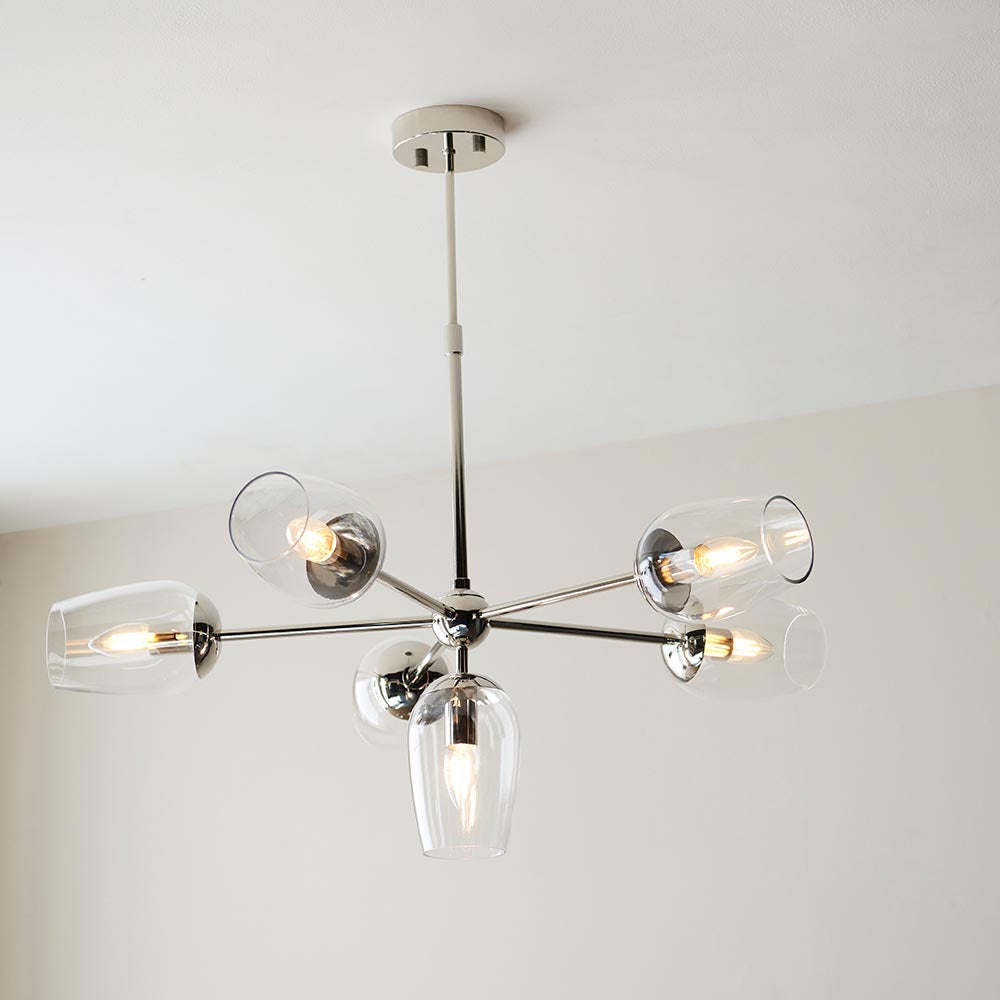 Endon Caldworth 6 light pendant in polished nickel with slender curved arms and clear blown glass shades, mounted to a ceiling in a neutral room.