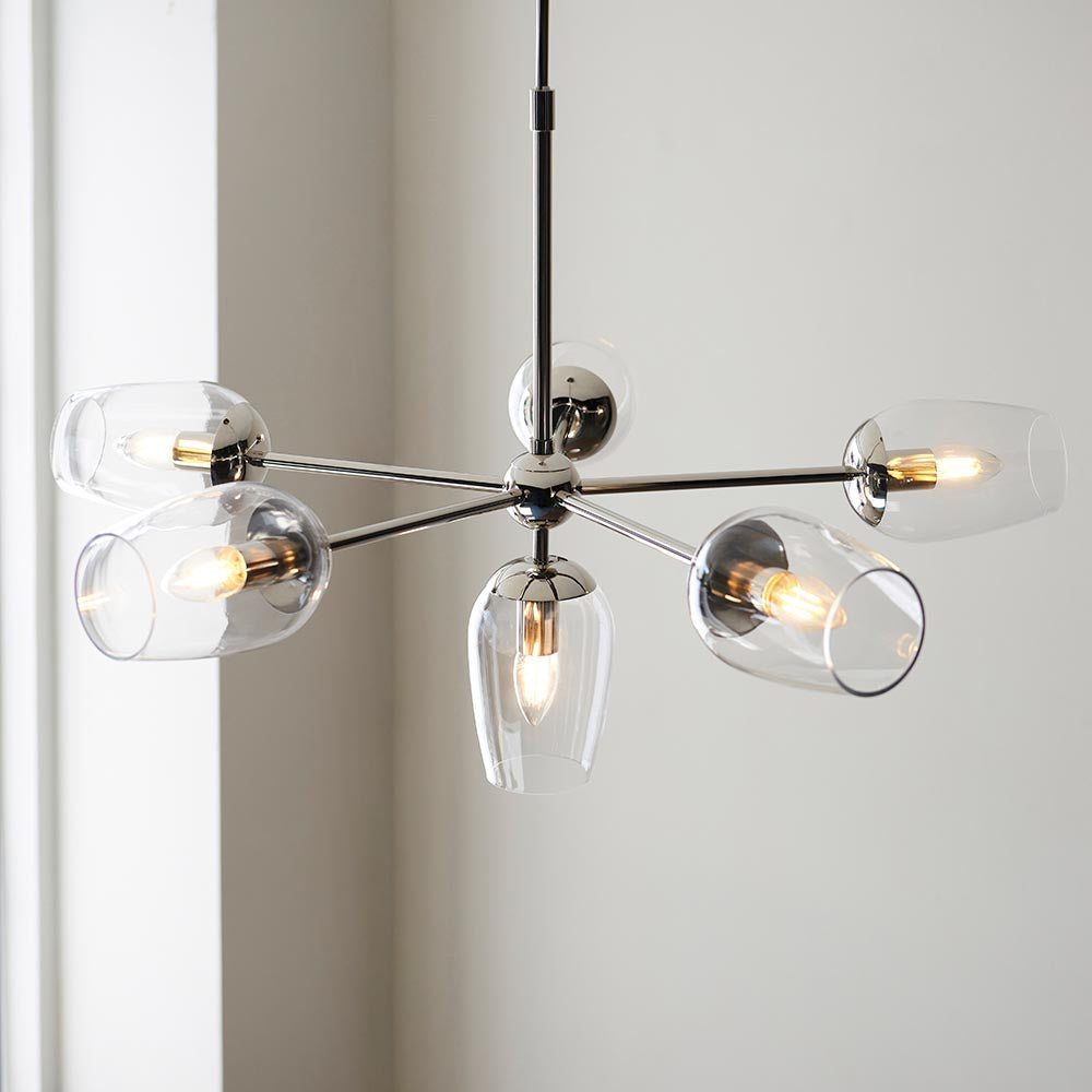 Endon Caldworth 6 Light Pendant in nickel with slender curved arms and clear blown glass shades, shown hanging by a window against a pale wall.
