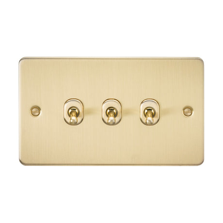 The 10AX 3 Gang 2-Way Toggle Switch in brushed brass flaunts a modern design with three horizontal toggle switches. Its sleek and minimalist appearance highlights the flat plates golden hue against a white backdrop.