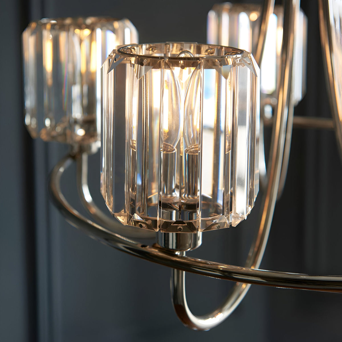 Close-up of the Clementine 5 Light Pendant in nickel, showing faceted crystal glass shades on curved metal arms with visible bulbs.