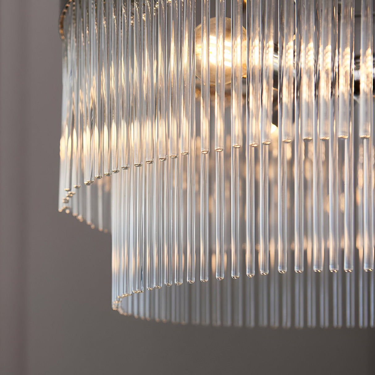 Close-up of the Beaumont 5 Light Pendant in nickel, showing tiered clear glass rods diffusing warm light from the E14 bulbs.