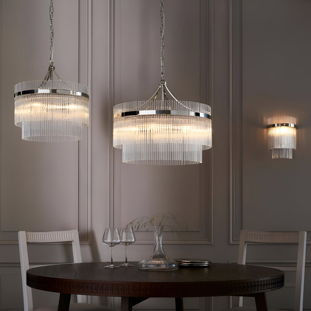 Beaumont 3 Light Pendant in nickel with tiered clear glass rods, shown hanging above a dining table alongside a matching wall light.