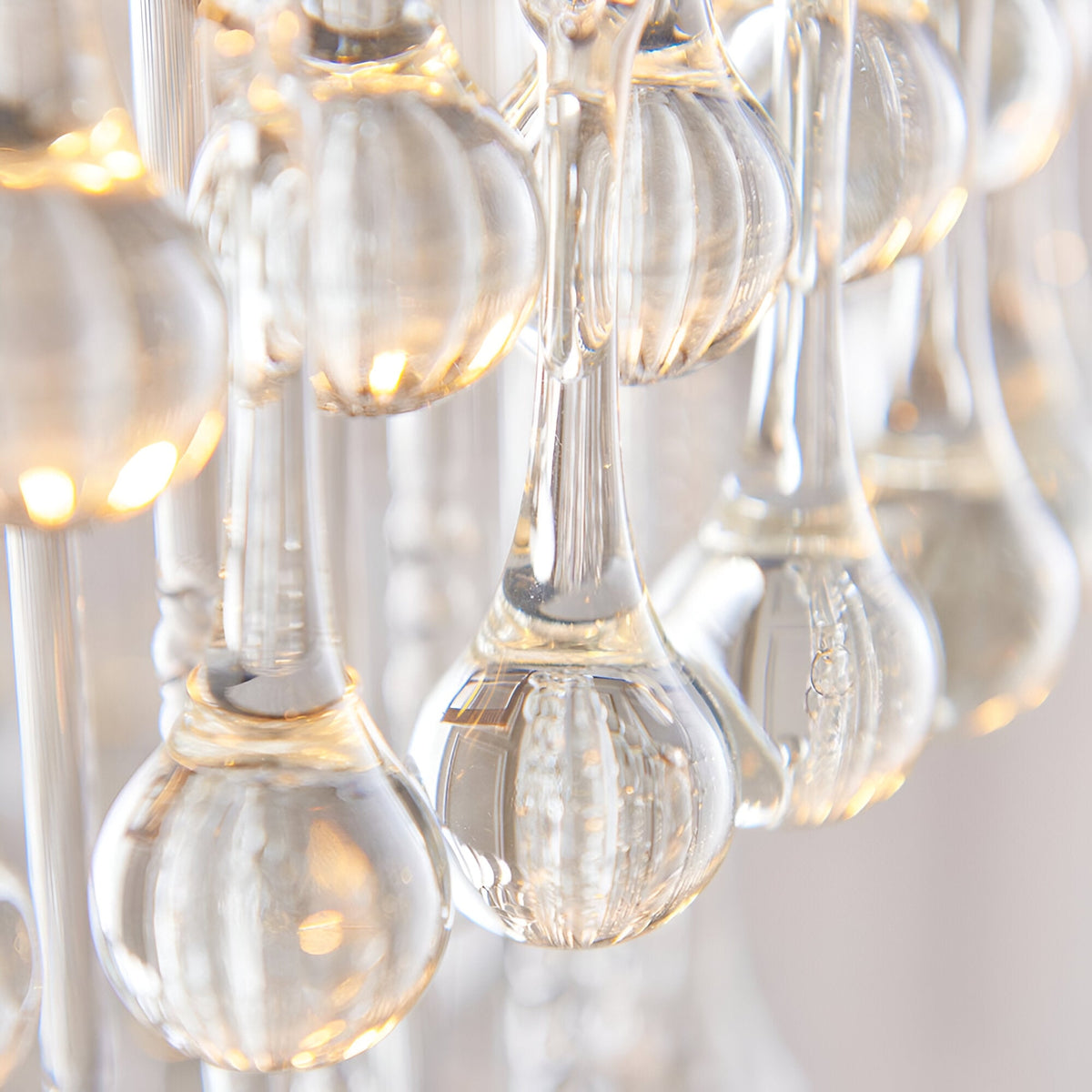 Close-up of the Bramgrove Pendant in antique brass, showing clear glass droplets catching warm light for a soft sparkle effect.