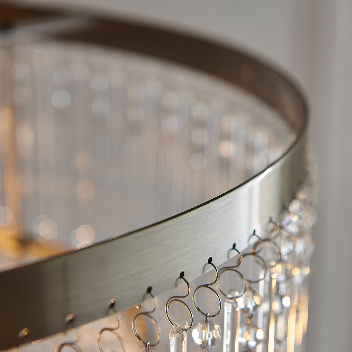 Close-up of the Endon Bramgrove pendant showing the antique brass frame rim and tiered clear glass droplets suspended below.