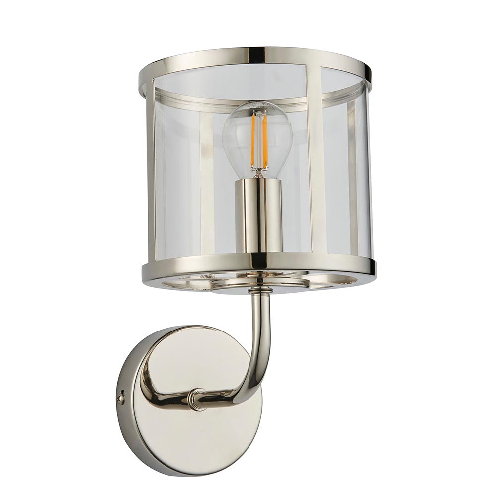 Ellery Wall Light in nickel with a round clear glass shade, exposed filament bulb, and curved arm on a circular backplate, shown on a plain white background.