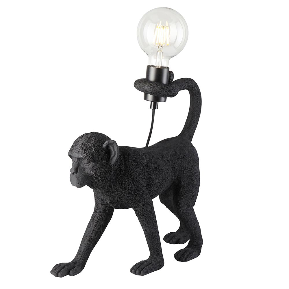 Belvoir Table Lamp in matt black resin, shaped as a detailed monkey holding an exposed filament bulb, shown on a plain white background.