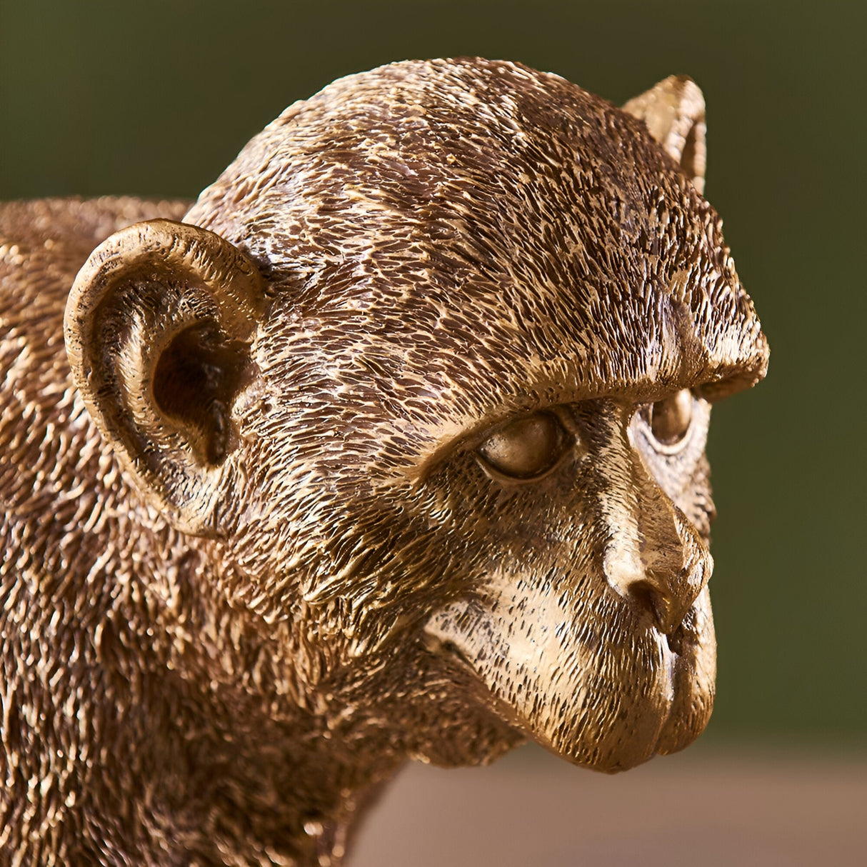 Close-up of the Endon Belvoir table lamp showing the detailed resin monkey head and ears in a warm vintage gold finish.