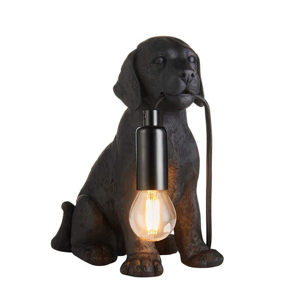 Endon Brockworth table lamp shaped as a matt black resin Labrador puppy holding an E14 filament bulb by a black cable, on a plain white background.