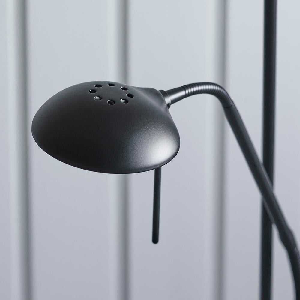 Close-up of the Endon Cliffcombe reading arm in matt black, with a perforated dome shade on a flexible neck against a light grey panelled backdrop.