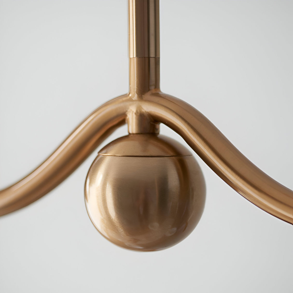 Close-up of the Endon Cliffleigh linear pendant showing the brushed aged brass bar, central stem junction, and decorative sphere detail.
