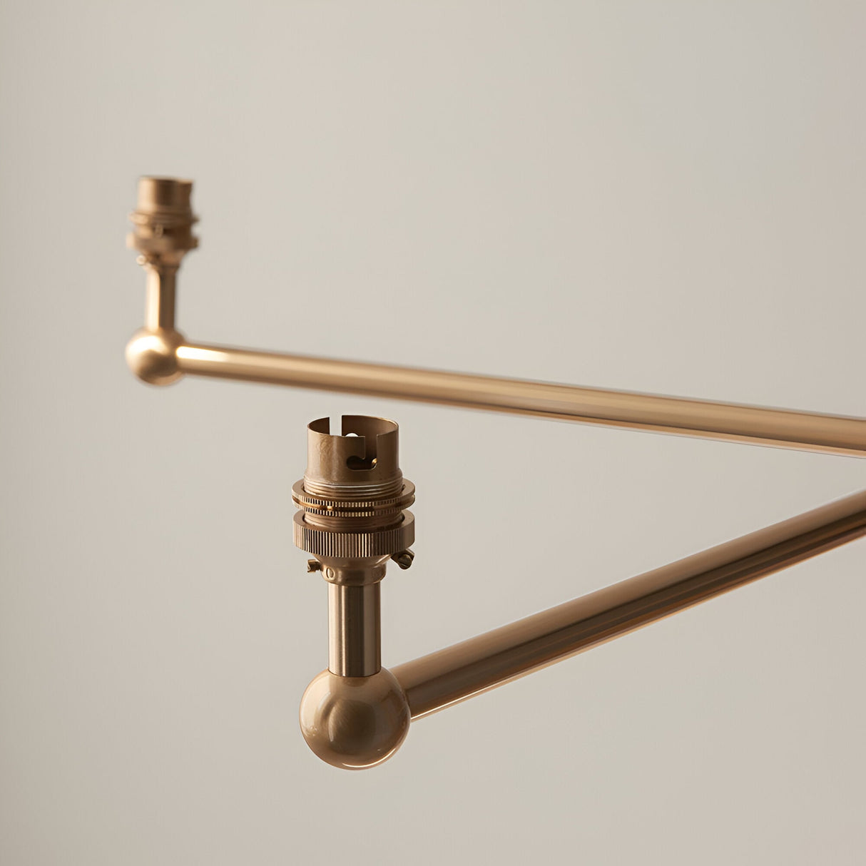 Close-up of the Cliffleigh 5 light pendant's brass arms and B22 lamp holders, showing brushed aged brass finish against a plain light background.