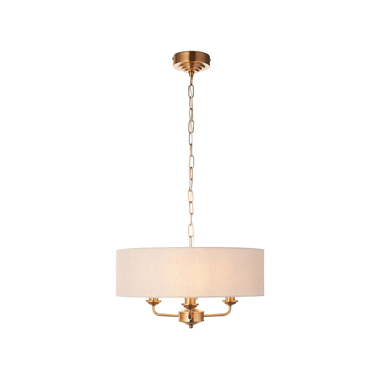 Brenley 3-light pendant with a natural linen drum shade on vintage brass plated metalwork and chain suspension, shown on a plain white background.