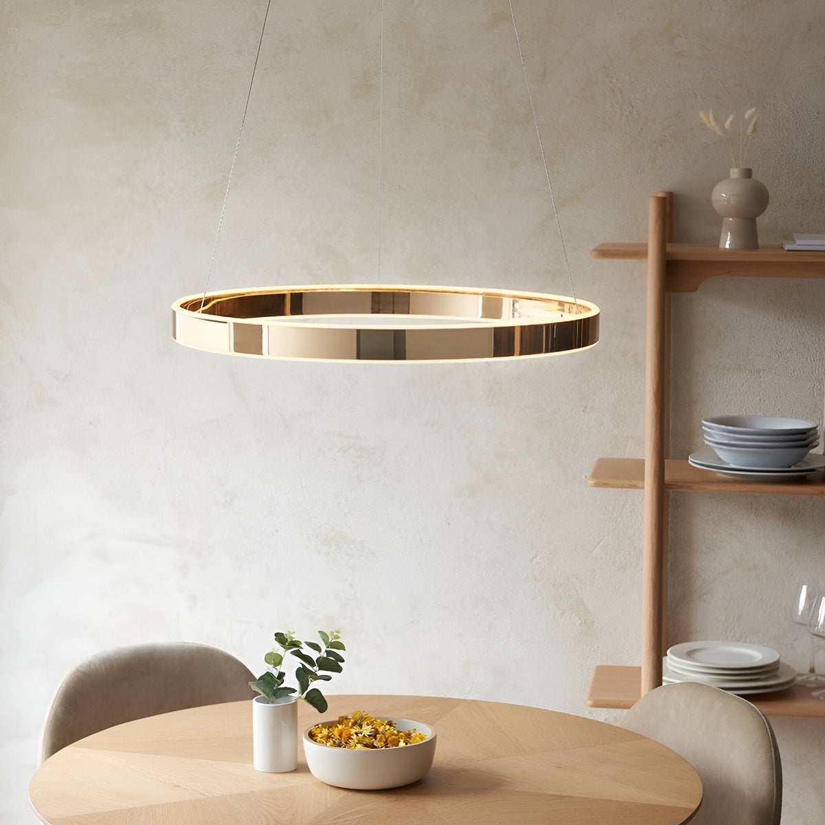 Endon Bramford gold ring LED pendant with frosted diffuser suspended on wire cables above a wooden dining table in a neutral modern room.