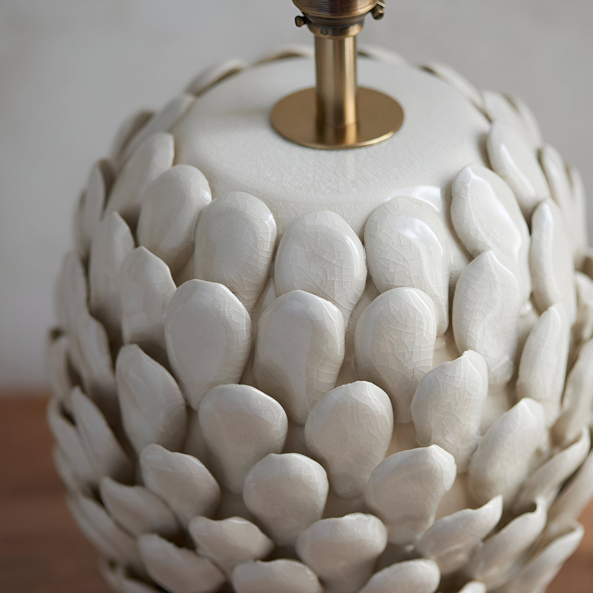 Caldford Small Table Lamp base in cream, close-up of ceramic leaf-shaped textured body with crackle glaze and brass fitting.