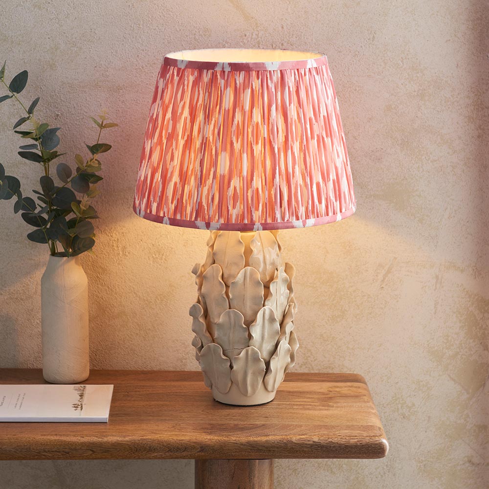 Endon Caldford Large Table Lamp in cream with sculptural leaf-detailed ceramic base and pink patterned pleated shade, styled on a wooden console table.