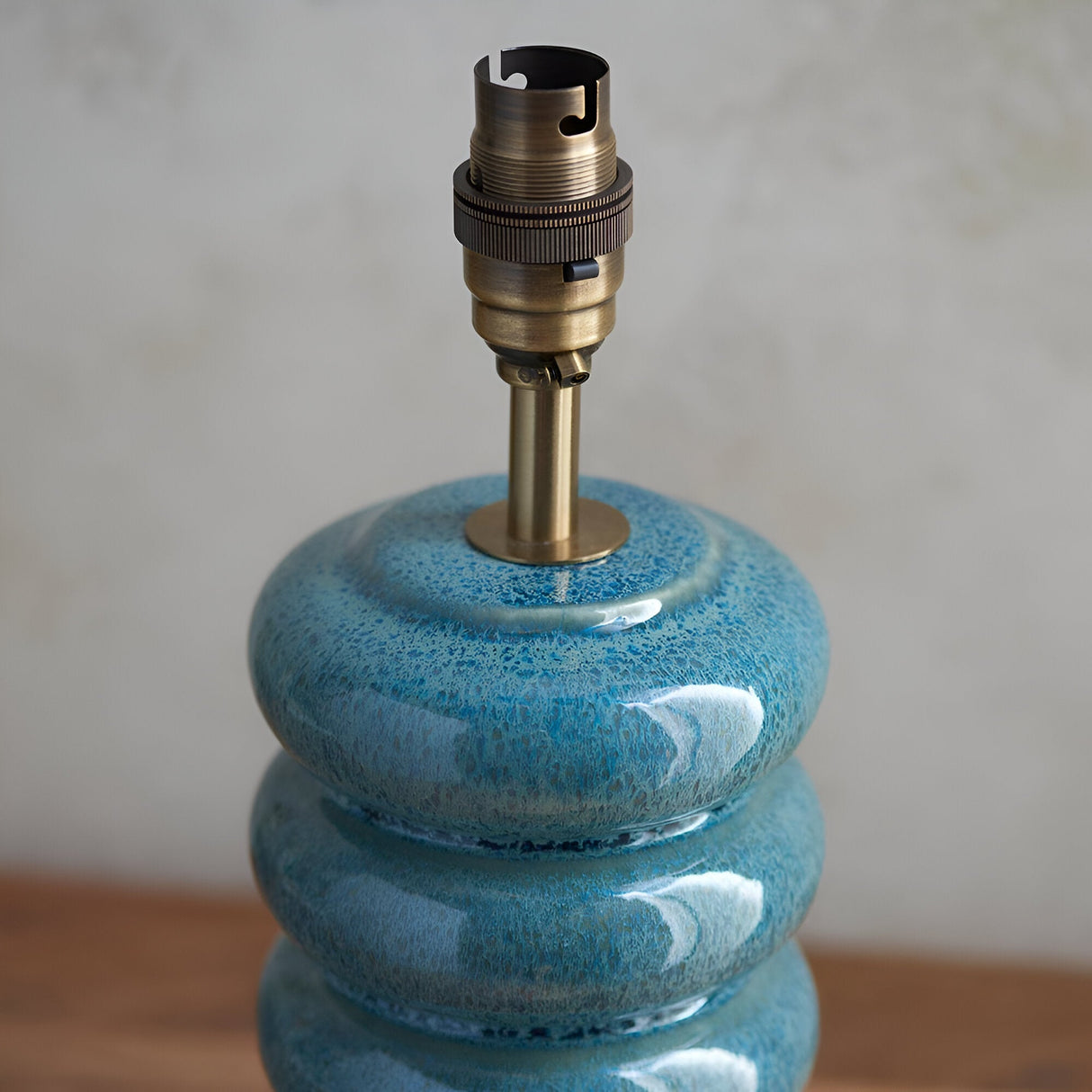 Cliffstead Table Lamp base in blue reactive ceramic glaze with stacked curved form, topped with a brushed antique brass switched B22 lamp holder.