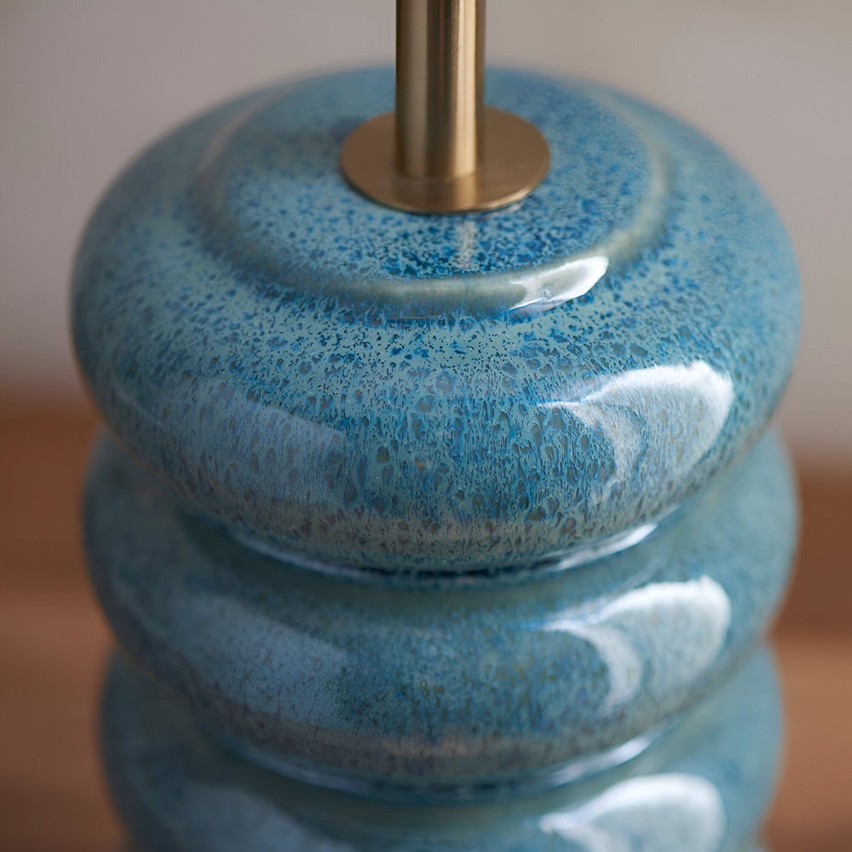 Cliffstead Table Lamp base close-up in ceramic with a blue ocean spray reactive glaze and stacked curved tiers, topped with a brushed brass fitting.