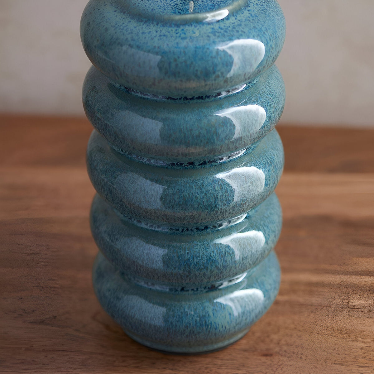 Cliffstead Table Lamp base in ceramic with a stacked ribbed design and ocean spray blue reactive glaze, shown on a wooden surface.