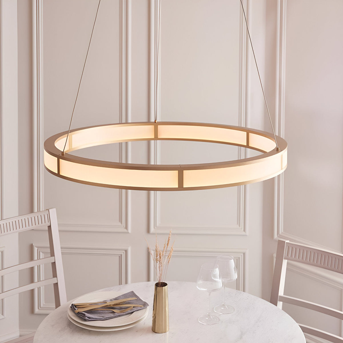 Endon Bevley brushed gold LED ring pendant with ribbed frosted acrylic diffuser, suspended on clear cables above a dining table in a panelled room.