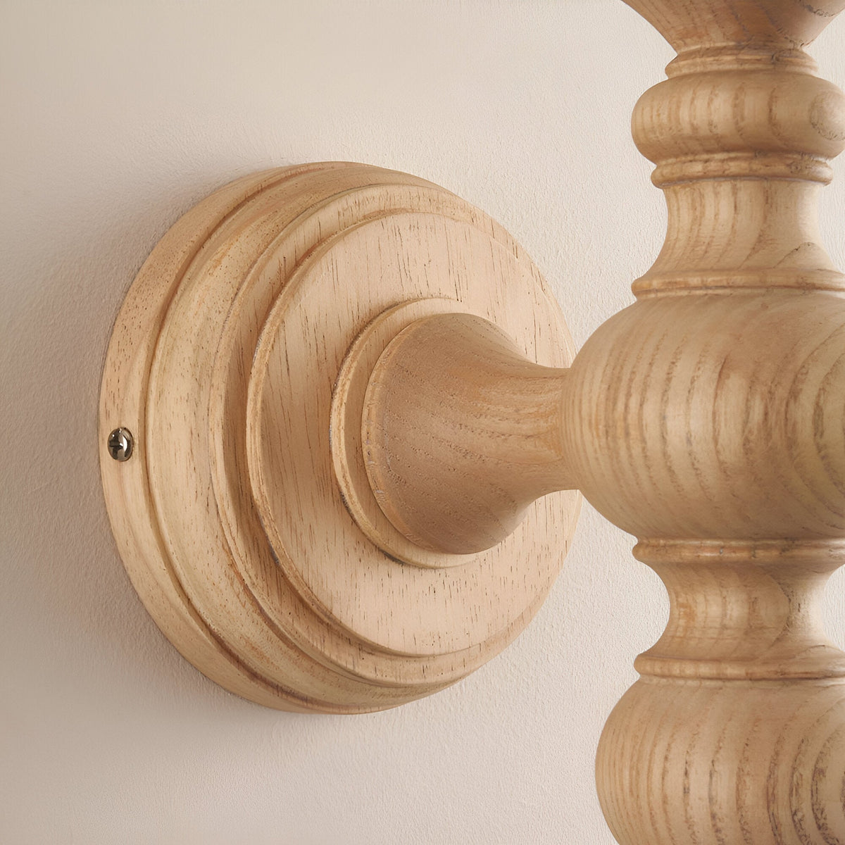 Close-up of the Endon Aldworth wall light in natural ash, showing the turned solid wood spindle and round wall plate mounted to a pale wall.