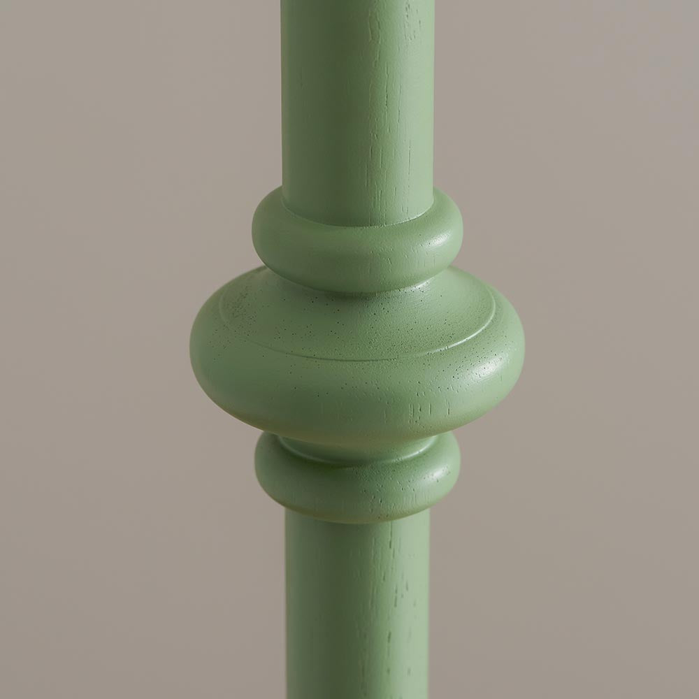 Close-up of the Endon Bevbury floor lamp's turned wooden spindle detail in Cotswold green satin paint against a neutral background.