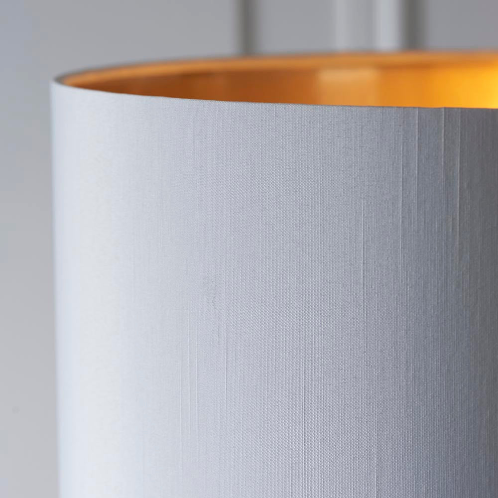 Close-up of the Endon Brenley floor lamp shade in white faux silk with a reflective gold metallic inner lining.
