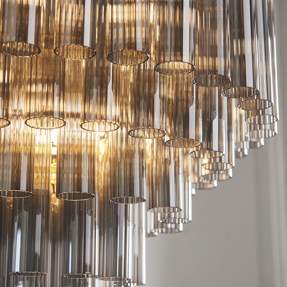 Close-up of Endon Cranshaw 12 Light Tiered Pendant in satin brass with smokey grey lustre cylindrical glass tubes arranged in layered tiers.