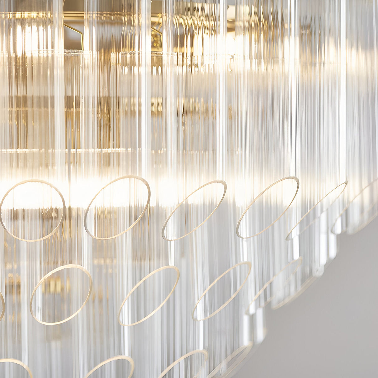 Close-up of the Cranshaw 12 Light Tiered Pendant in brass, showing clear ribbed glass rods and satin brass rings arranged in layered tiers.