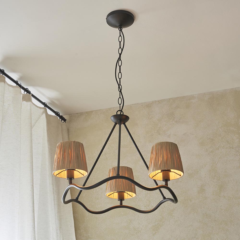 Endon Danemont 3 light pendant in black with a wave-shaped hoop carrying three tapered raffia shades, suspended by chain from a ceiling in a living space.
