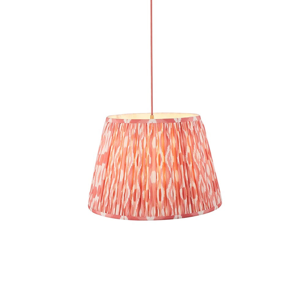 Endon Brackmont Ikat Coral pendant light with a handmade pleated tapered faux silk shade in pink and red, on a red braided cable, against a white background.