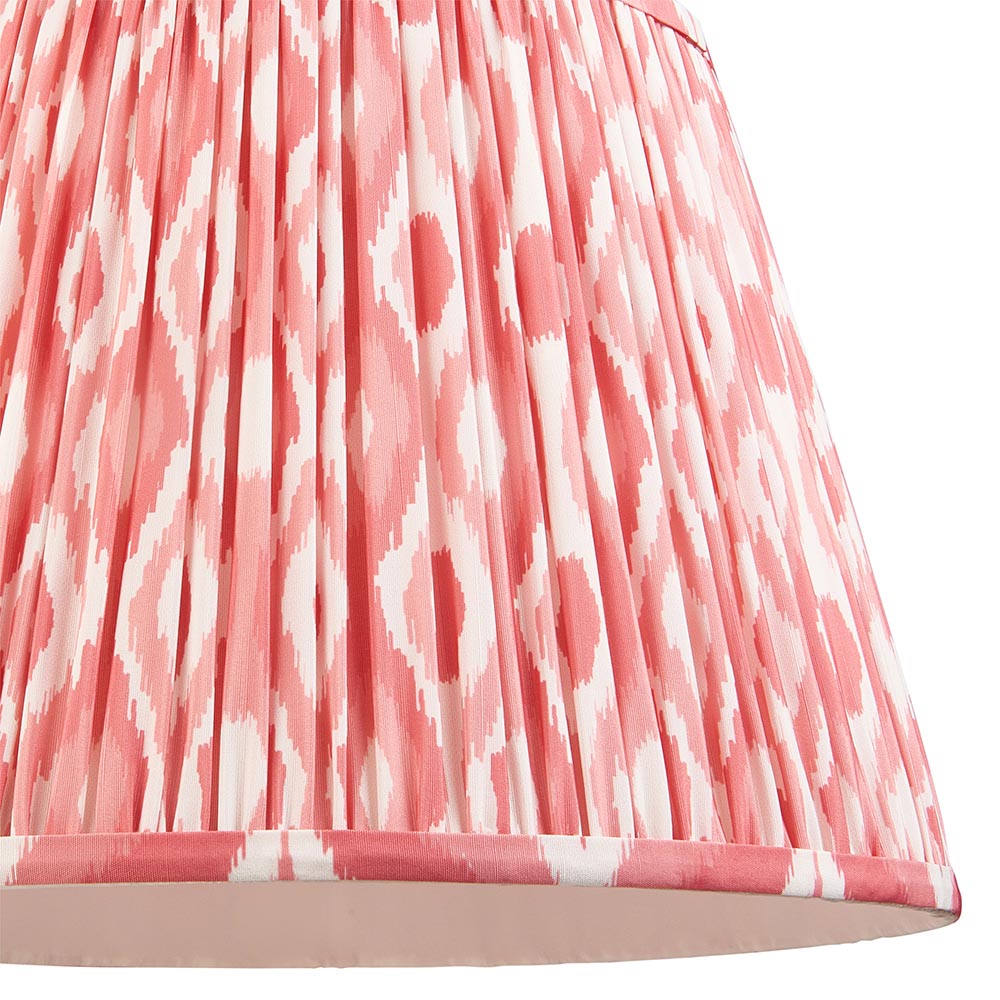Close-up of Endon Brackmont Ikat Coral pendant shade, showing handmade pleated faux silk in coral pink and white Ikat print with taped edge trim.
